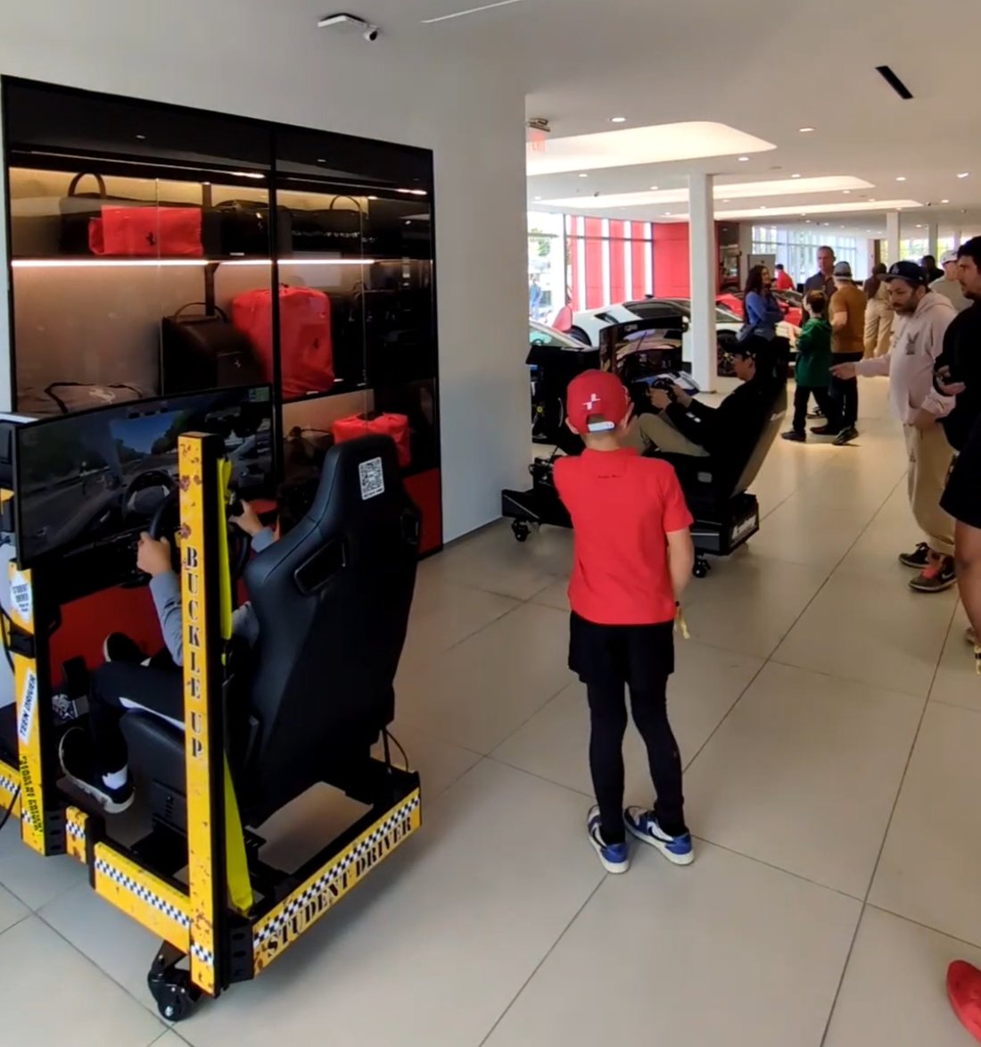 Crowd of guests watching and racing at a Ferrari showroom activation